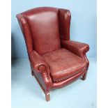 A modern Parker Knoll, burgundy leather upholstered wing-back armchair, raised on squared