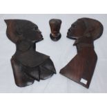 A pair of wall hanging carvings depicting an African man and woman in profile, 50cm high, together