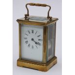 A French brass cased carriage clock with white dial, black Roman numerals, four bevelled glass