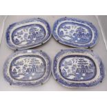 Two large serving platters in the 'Willow' pattern, together with a two slightly smaller platters in