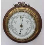 A bulkhead aneroid barometer in circular brass case by John Baker & Co Ltd, Kensington, mounted on