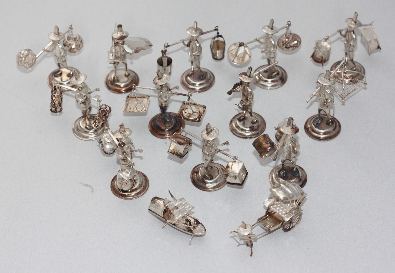 A set of fourteen novelty silver place name holders modelled as Oriental figures, marked 'Silver