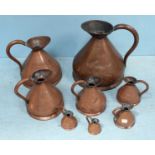 A set of eight graduated copper haystack jugs, the tallest measures 40cm high.