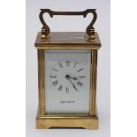 A brass carriage clock by Mappin & Webb, white dial, Roman numerals, swing handle and bevelled