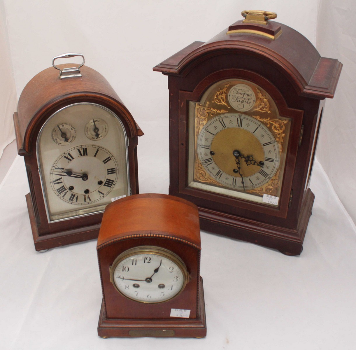 A mahogany cased bracket clock with arched top marked 'Tempus Fugit', silvered dial with Roman