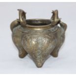 A Chinese bronze tripod censer, with scrolling fruiting handles, relief moulded dragons chasing