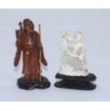 An oriental carved boxwood figure of an elderly oriental man in robes with staff and knapsack,