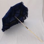 An Edwardian ladies parasol with two-piece bone handle, brass runners and blue floral canopy.