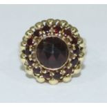 A 14ct gold dress ring set with a large central round faceted amethyst ring and further surrounded