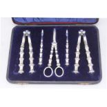 A set of silver-plated nutcrackers, picks and grape scissors in blue velvet lined case