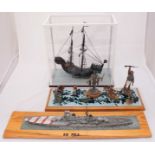 A carved wooden ship in glazed display case, together with a scale model of RN Pola on wooden plinth