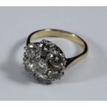 An 18ct gold diamond cluster ring claw-set with seven round brilliant-cut diamonds. The diamonds