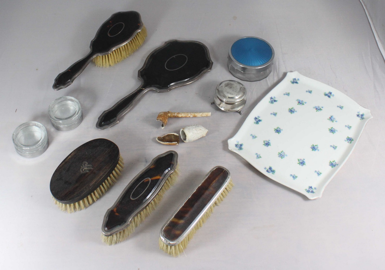 A three-piece silver and tortoiseshell brush and mirror set, another silver-tortoiseshell clothes