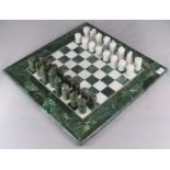 A white and green marble chess board and pieces