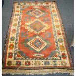 A hand-knotted tufted carpet of Caucasian design with stylised guls within geometric multi-