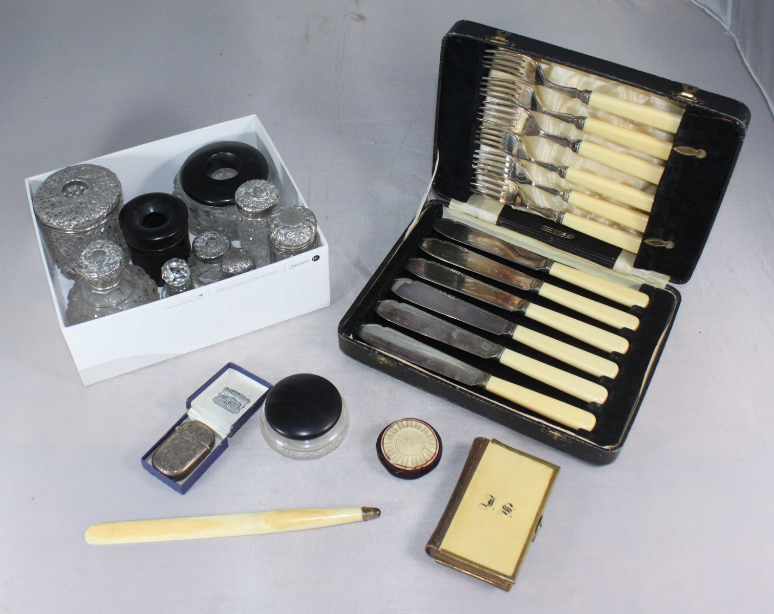 An Edwardian silver vesta case together with six silver-topped cut glass toilet jars, three ebony-