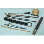 A swagger stick and two various canes, together with assorted wrought iron fire implements, a Smiths