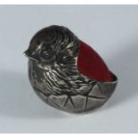 A silver pin cushion modelled as a chick with red back, Chester, 1908, maker's mark of Sampson