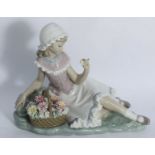A boxed Lladro porcelain figure 'Florinda', modelled as a girl lying next to a basket of flowers, on