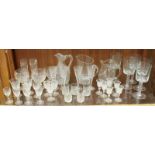 A shelf of assorted crystal glassware including five large twist-stemmed wine glasses, sherry