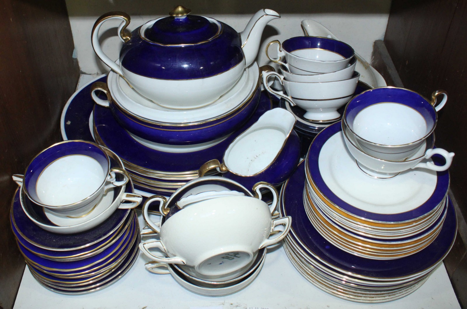 SECTION 20. A quantity of Aynsley dinner and tea wares in white with blue and gilded rims, including