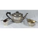 A 'matched' three-piece silver tea set, the teapot by Barker Brothers, hallmarked Chester 1909,
