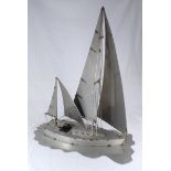 A modern fabricated metal sculpture of a sailing yacht, with sailor fashioned from wire and