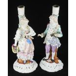 A pair of late 19th century Sitzendorf pastoral figures, later converted to candlesticks, (some