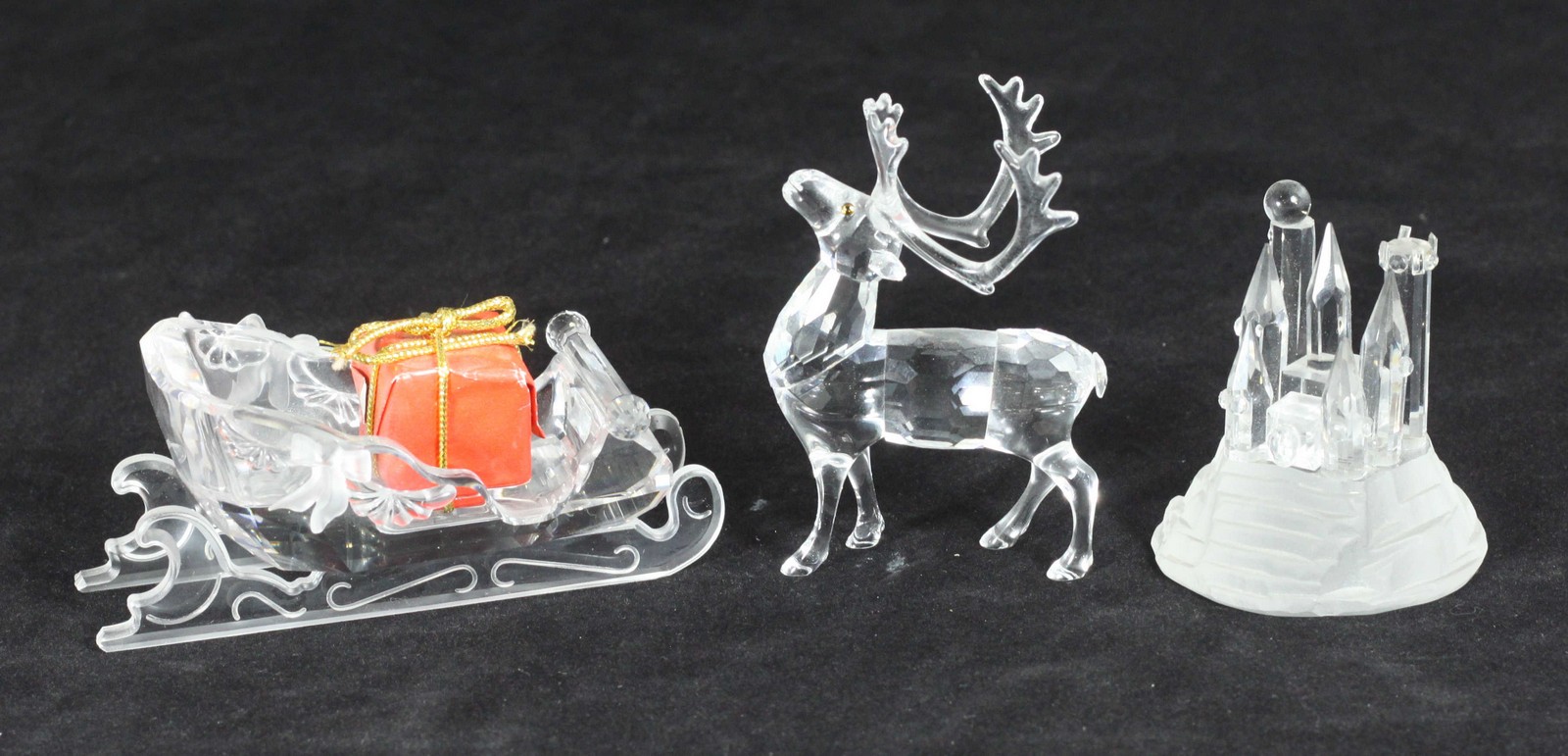 A Swarovski crystal model of a reindeer and sleigh with present, together with a Swarovski crystal
