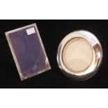 Two assorted silver photograph frames, one rectangular and one circular.