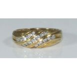 An 18ct yellow gold and diamond ring, the top of swirl design channel-set with seventeen small RBC