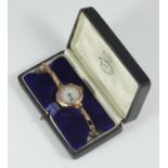 A 9ct gold ladies wristwatch, the white dial with blue Arabic numerals denoting hours and subsidiary