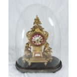 An ornate gilt spelter mantel clock, the case with floral finial and red dial with Roman numerals