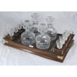 A Tudor crystal drinks set comprising four decanters and eight glasses on fitted wooden and brass