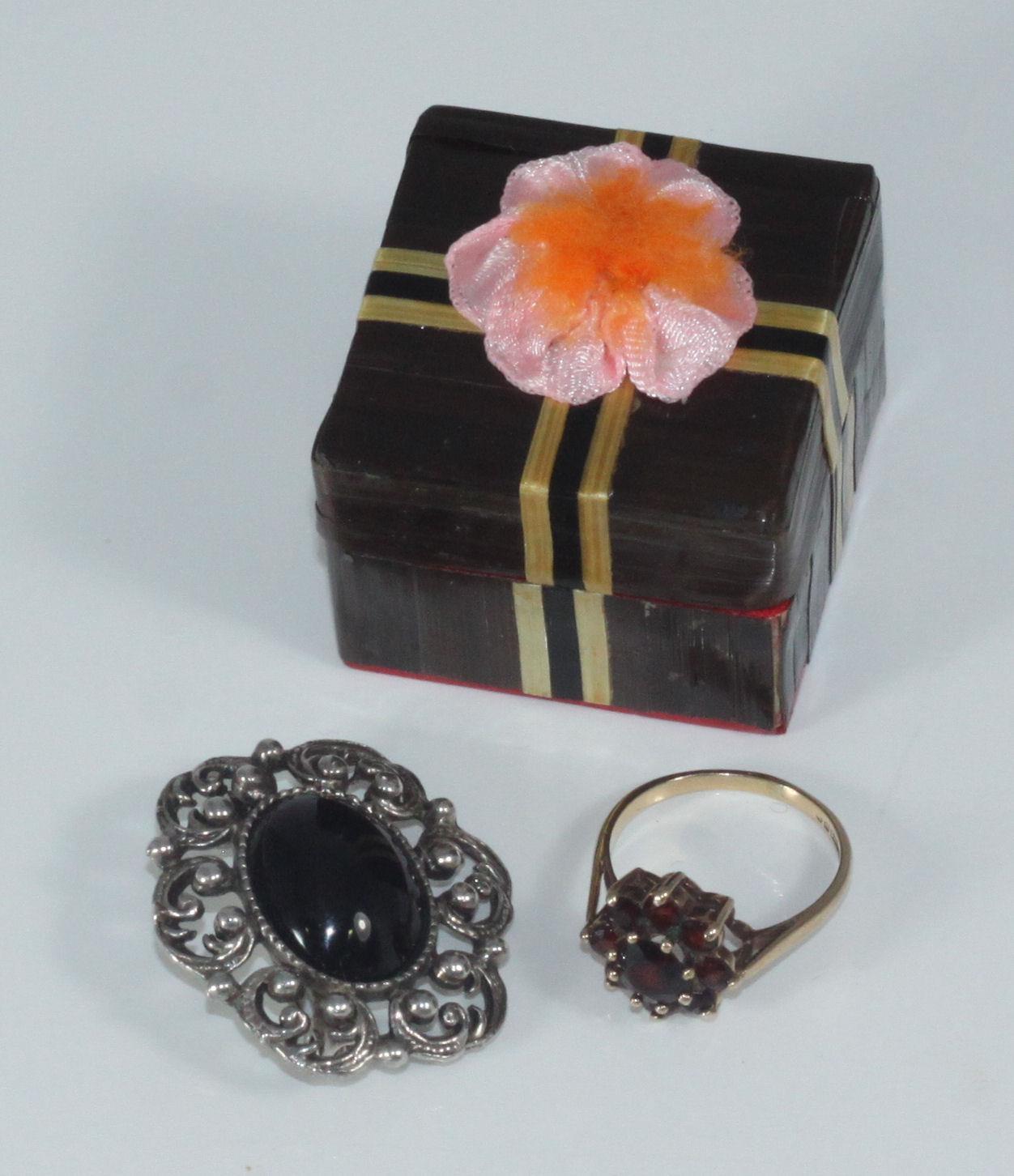 A 9ct gold and garnet tiered-cluster ring together with a costume jewellery brooch