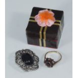 A 9ct gold and garnet tiered-cluster ring together with a costume jewellery brooch