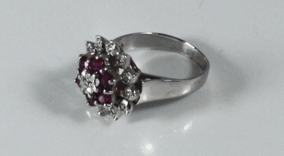 A 9ct white gold cluster ring set with thirteen small illusion set diamonds and six ruby coloured - Image 2 of 2