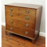 An oak chest of four long, graduated drawers, each with oval brass handles and escutcheons, raised
