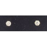 A pair of diamond solitaire stud earrings, each round brilliant cut diamond,weighing approximately