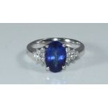 An 18ct white gold, Tanzanite & Diamond dress ring, claw-set an oval faceted tanzanite measuring