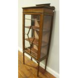 An Edwardian inlaid mahogany single door display cabinet, the glazed door enclosing two shelves,