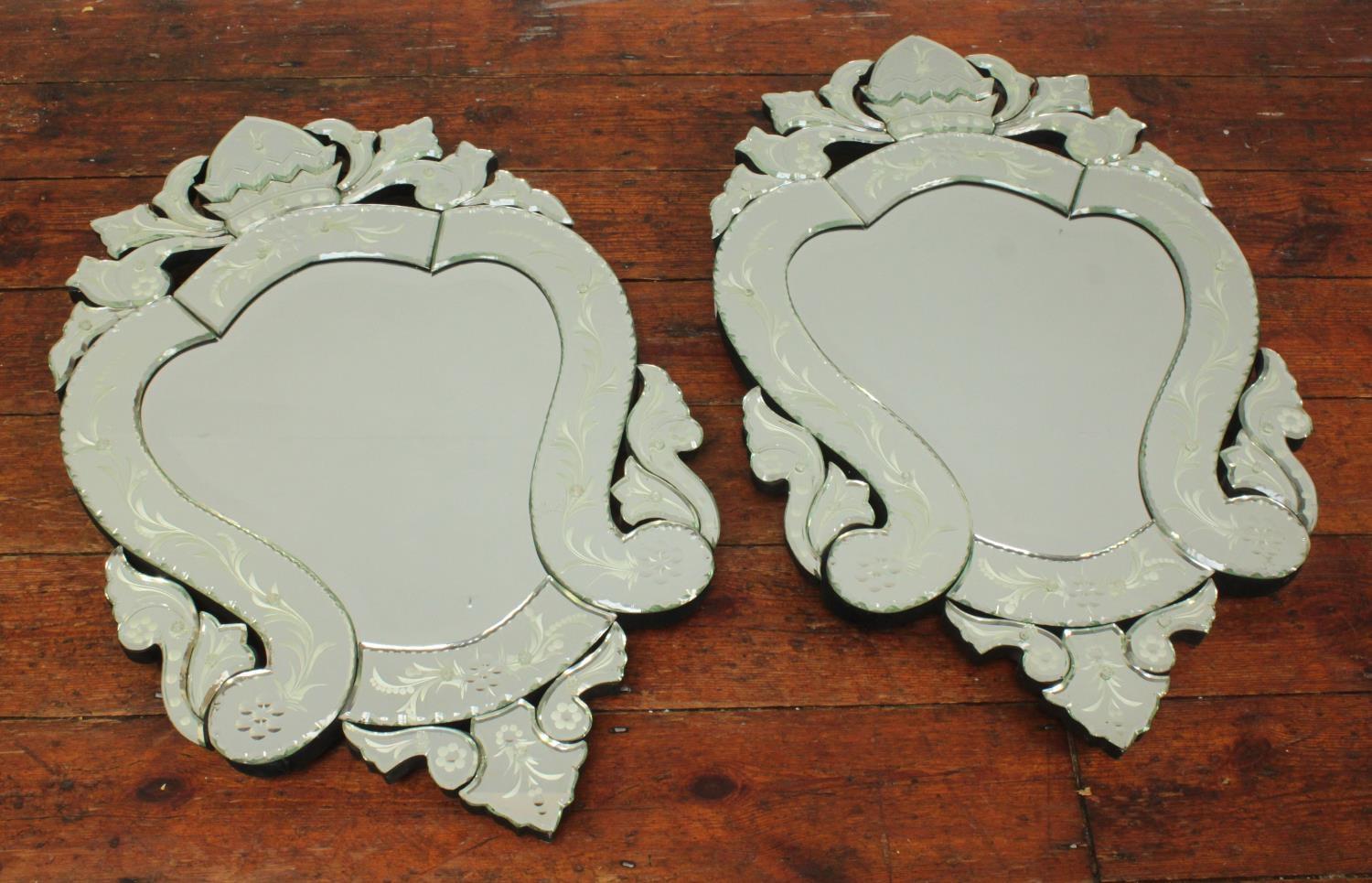 A pair of modern Venetian cut-glass mirrors, of cartouche shape with bevelled scrolling foliate