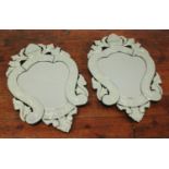 A pair of modern Venetian cut-glass mirrors, of cartouche shape with bevelled scrolling foliate