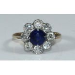 A unmarked yellow metal diamond and sapphire cluster ring, centrally set around- facetted