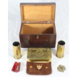 A small stained tea caddy, together with a WWI tin, two brass shell cases, a Royal Engineers badge