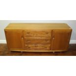An Ercol light elm 'Windsor' sideboard, with three central graduated drawers, flanked by two