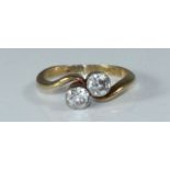 A 18ct diamond ring, of crossover design, set with two round Old Cut diamonds, estimated total