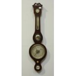 An Edwardian mercury wheel barometer with thermometer, hygrometer, small convex mirror and