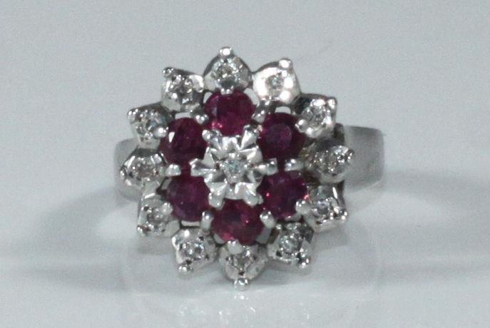 A 9ct white gold cluster ring set with thirteen small illusion set diamonds and six ruby coloured