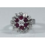 A 9ct white gold cluster ring set with thirteen small illusion set diamonds and six ruby coloured